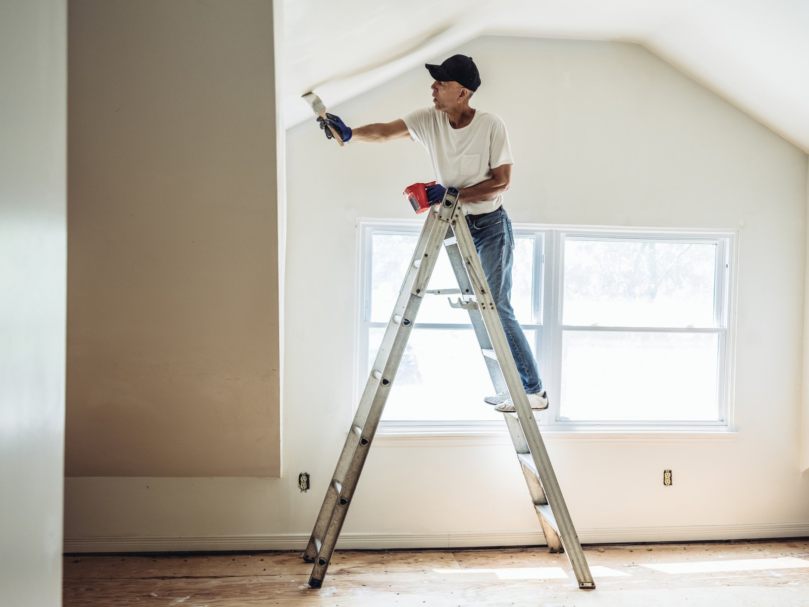 Senior man painting apartment interior